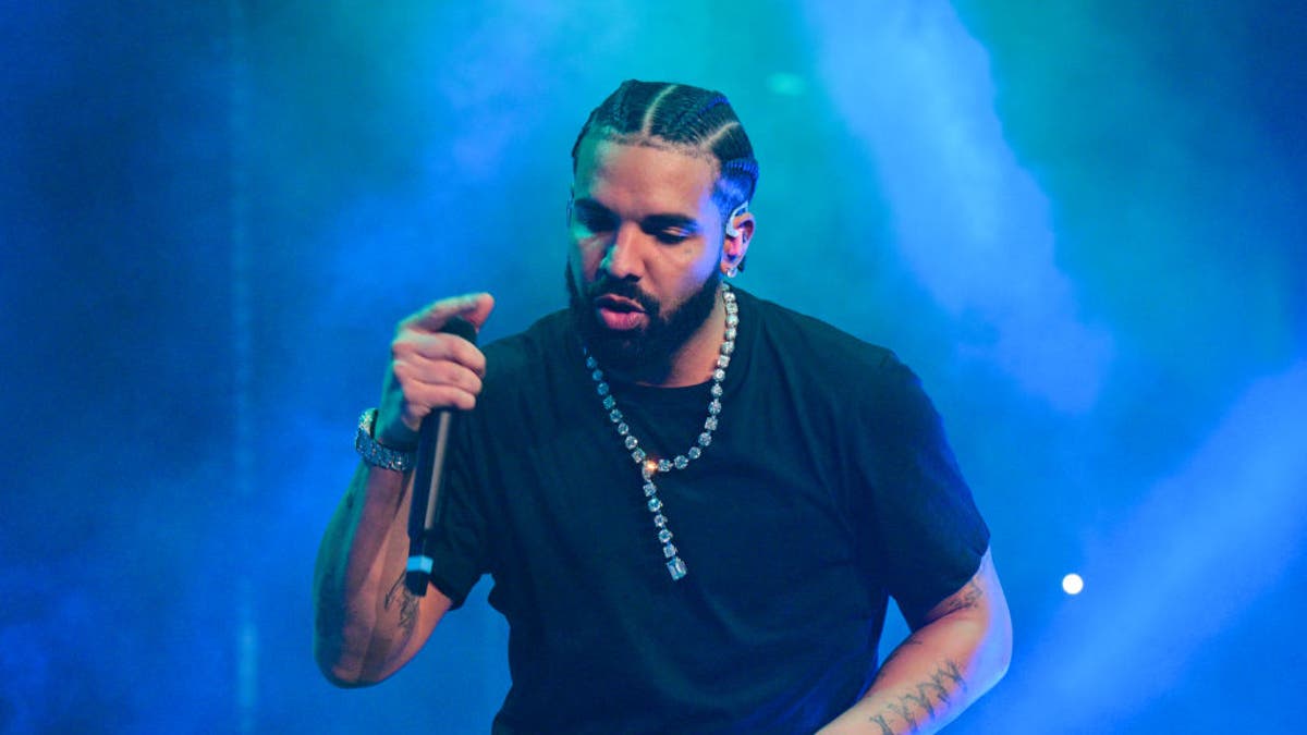 Drake viste una camiseta negra y actúa en el escenario de Atlanta