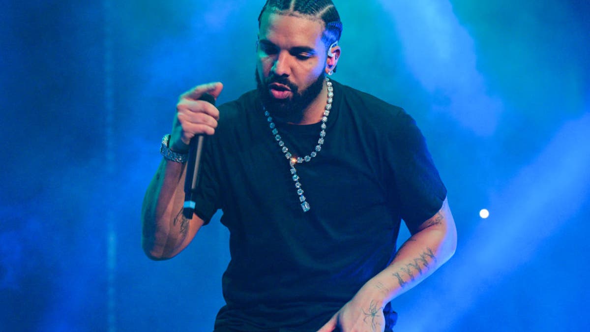 Drake wears a black shirt and performs on stage in Atlanta