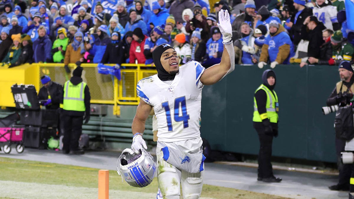 Amon-Ra St. Brown greets fans after defeating the Packers