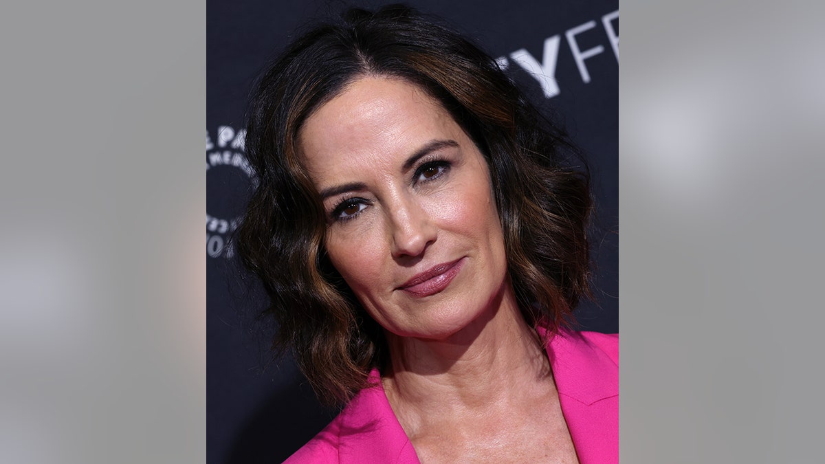 Wendy Moniz with short curly brown hair and a hot pink jacket on the red carpet of PaleyFest 2023