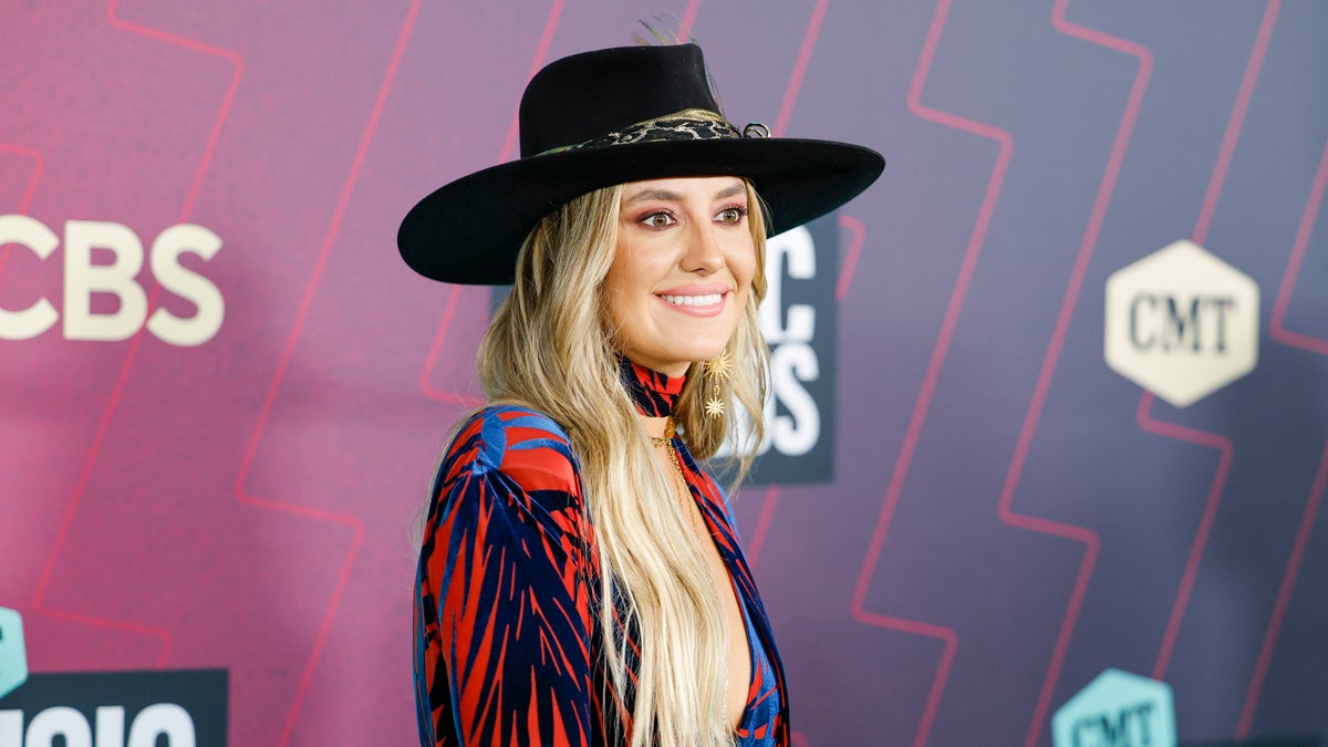 Lainey Wilson wears a hat and multi colored outfit at the CMT Music Awards