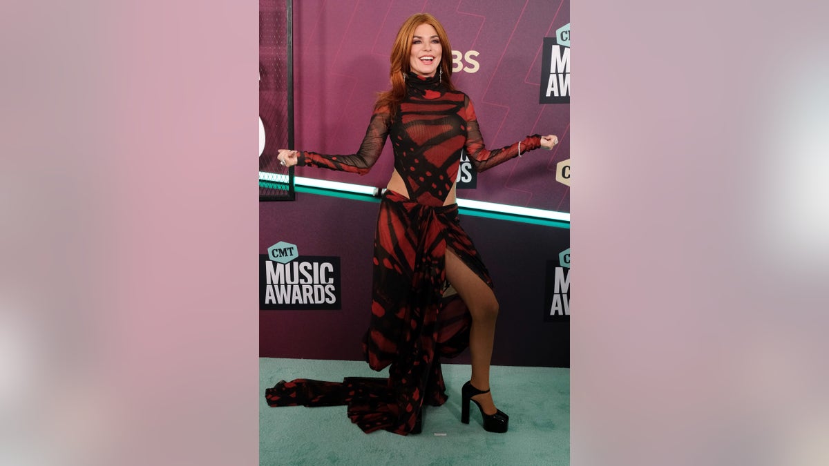 Shania Twain in a red and black cut out gown at the CMT Music Awards Red Carpte