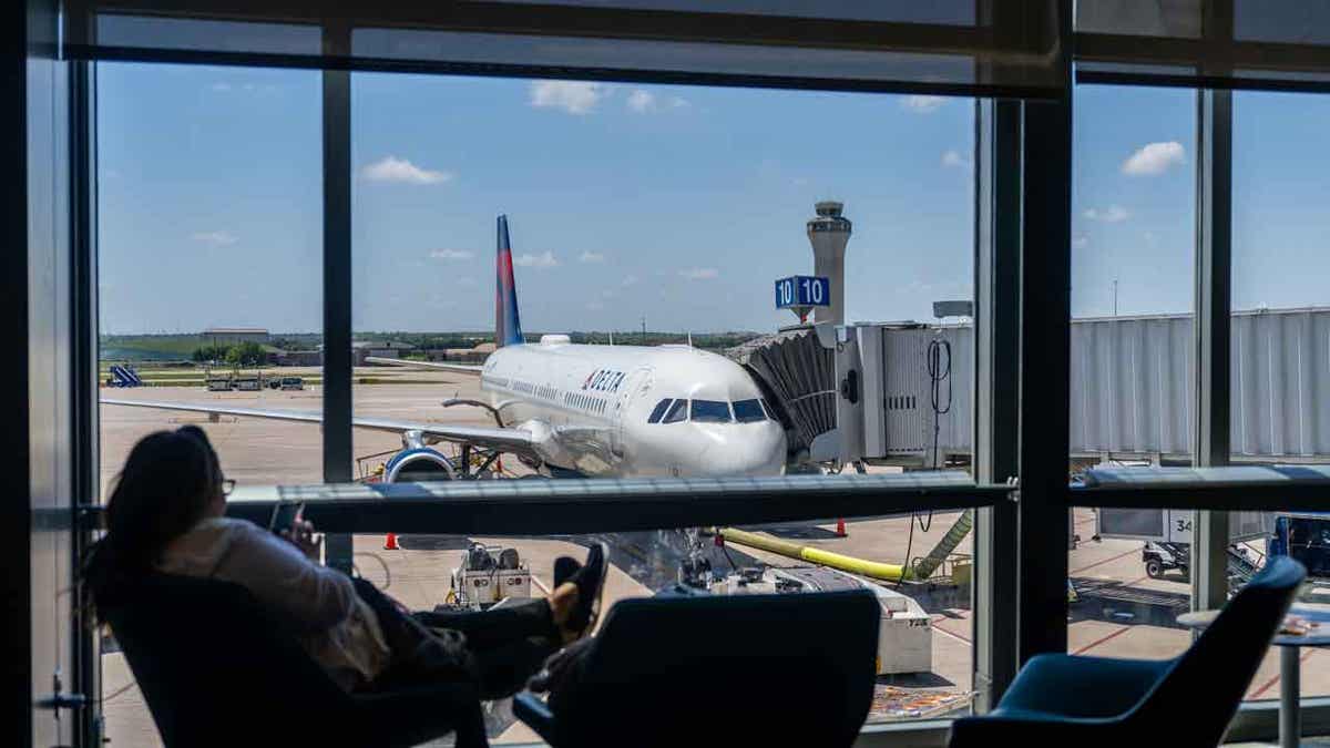 A passenger waits near a Delta Air lines terminal 
