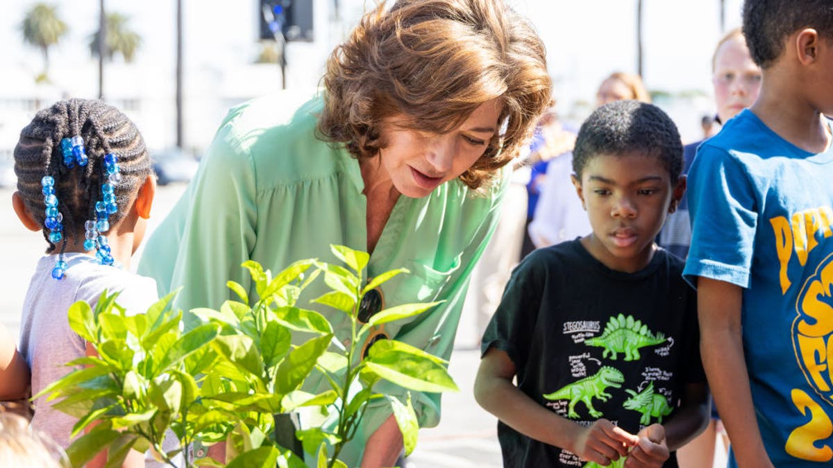 amy grant planting a tree with student