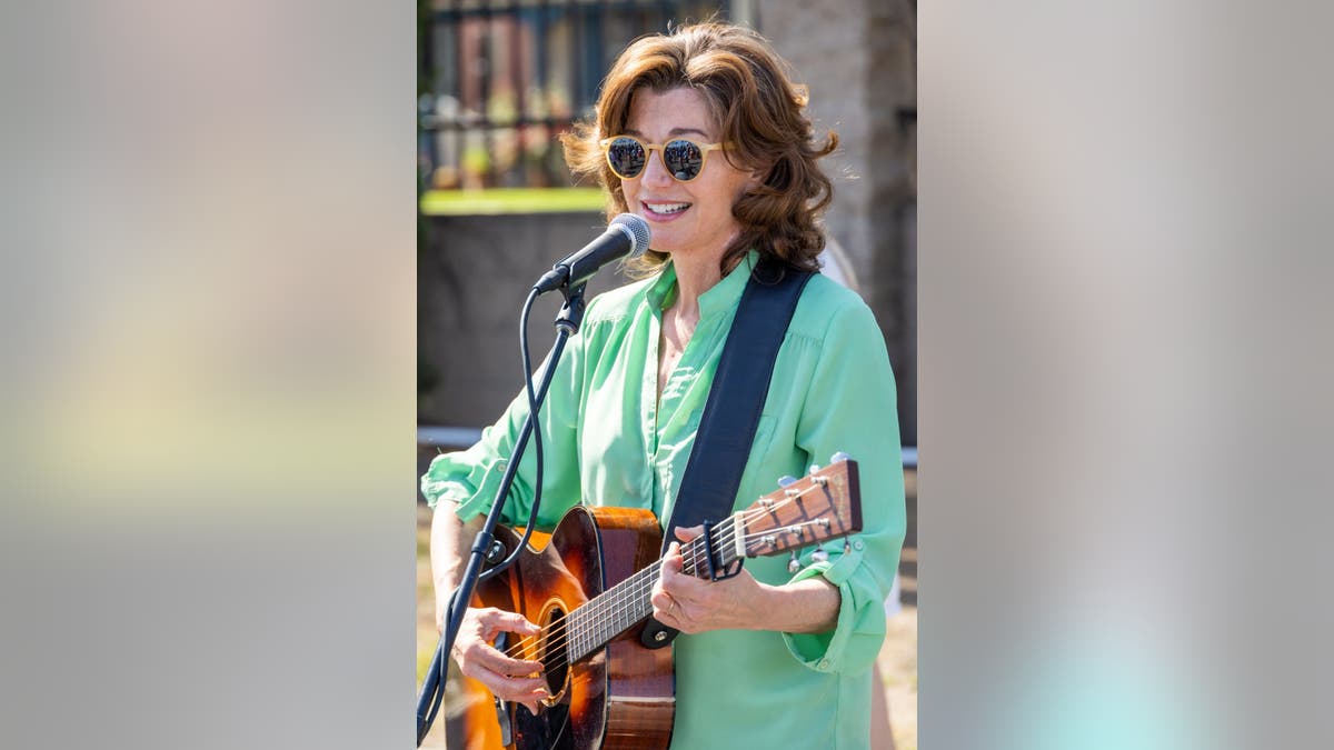 amy grant playing guitar at earth day event