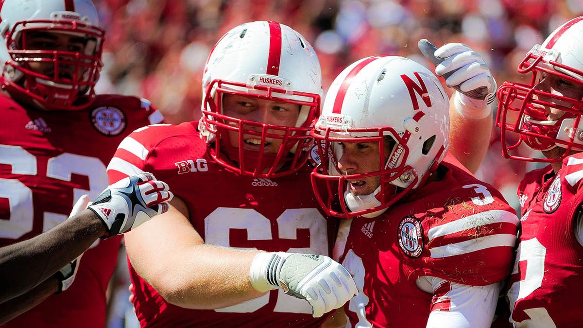 Nebraska offensive linesman Cole Pensick congratulates quarterback Taylor Martinez