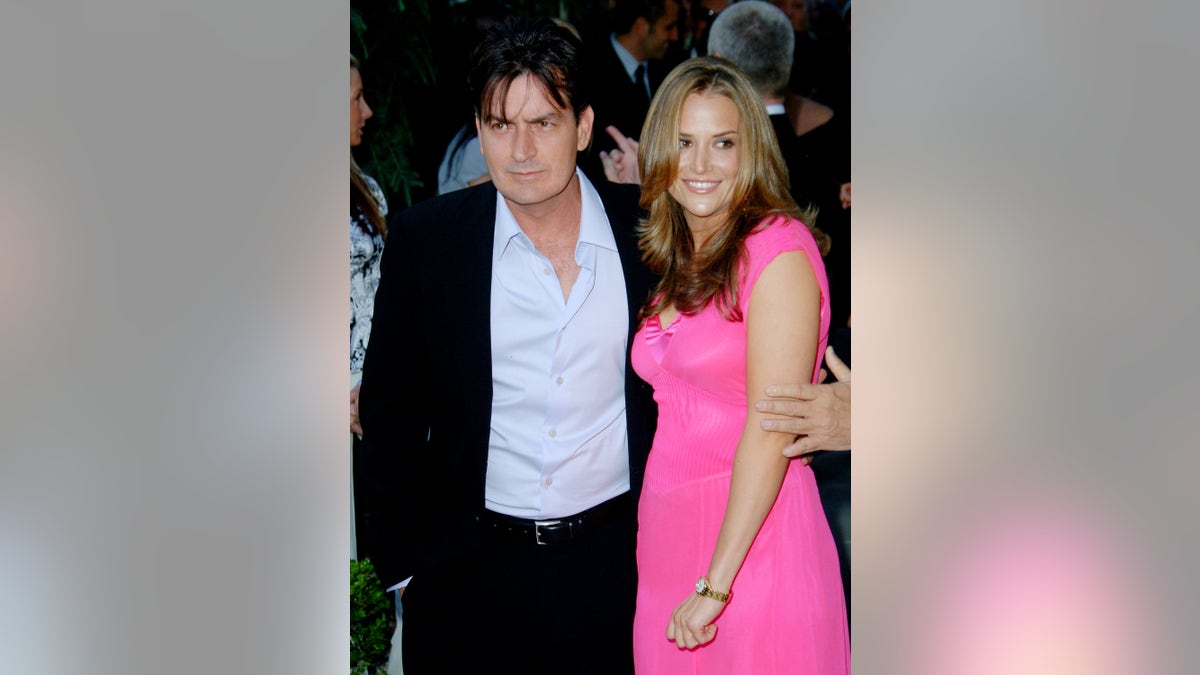 Charlie Sheen has his arm around Brook Mueller