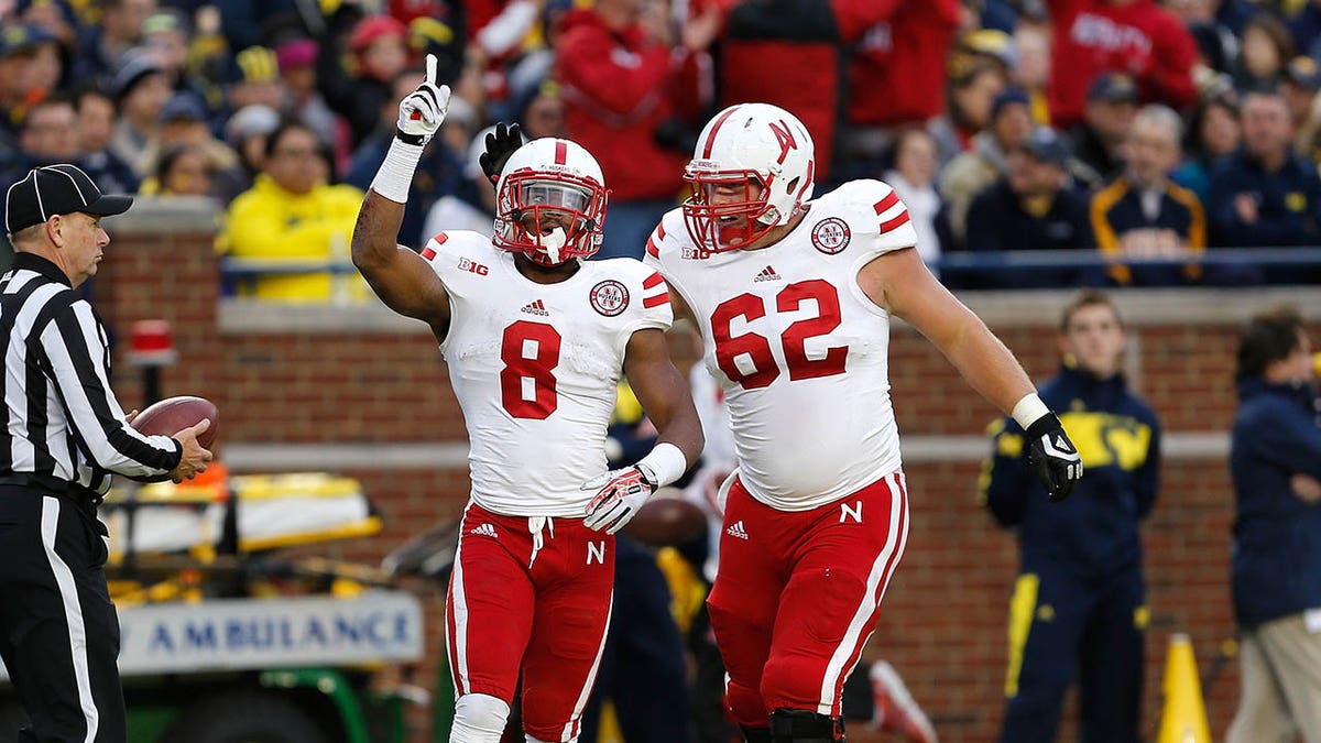 Nebraska offensive lineman Cole Pensick celebrates a touchdown with Ameer Abdullah