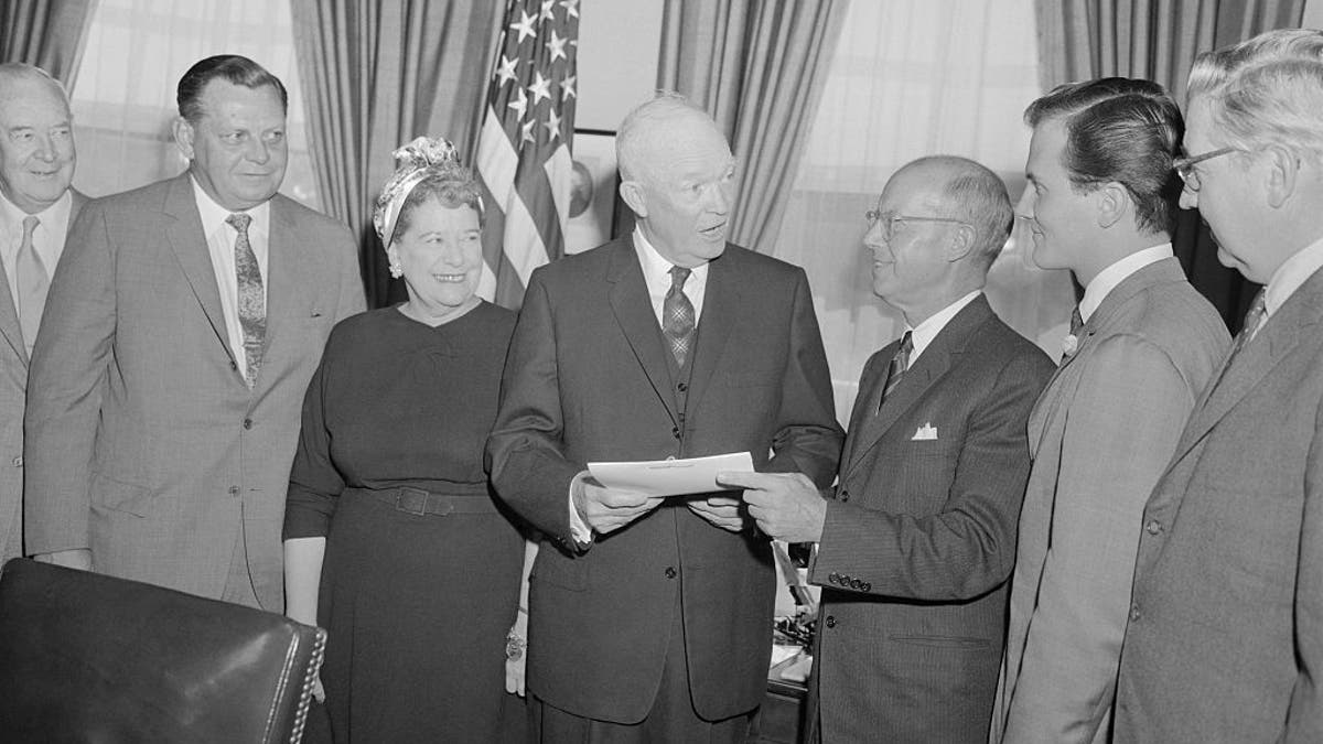 President Eisenhower in oval office with H.E. Humphreys, Jr., chairman of the board of the U.S. Rubber Company; and National Chairman of National Bible Week; and singer pat Boone, right, honorary co-chairman.