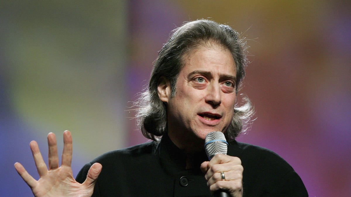 Richard Lewis with a microphone performing stand up