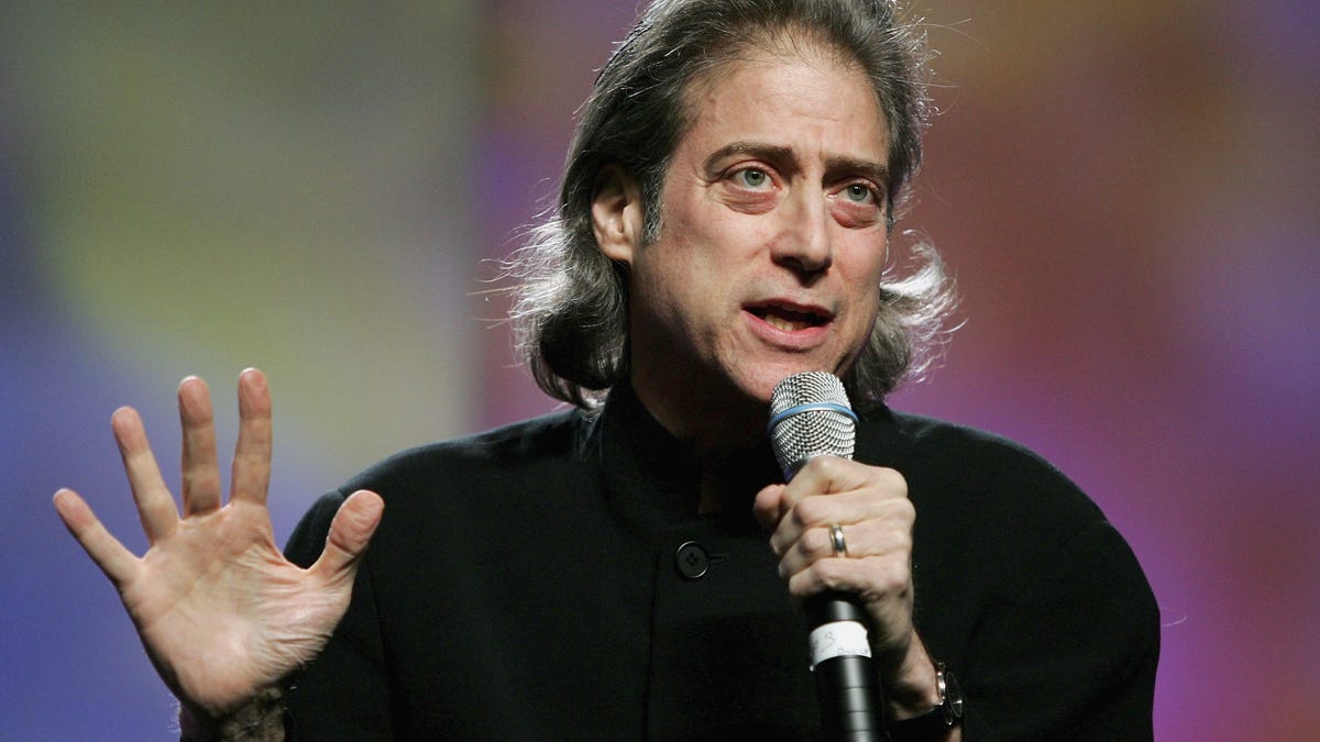 Richard Lewis with a microphone performing stand up