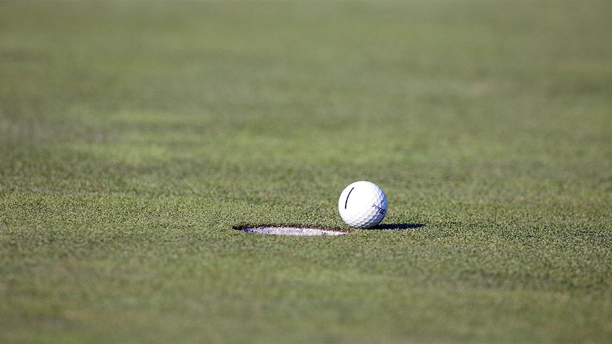 A golf ball falls short of the hole