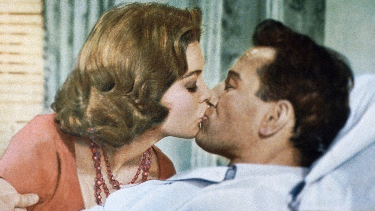 A close-up of Angie Dickinson kissing Richard Burton