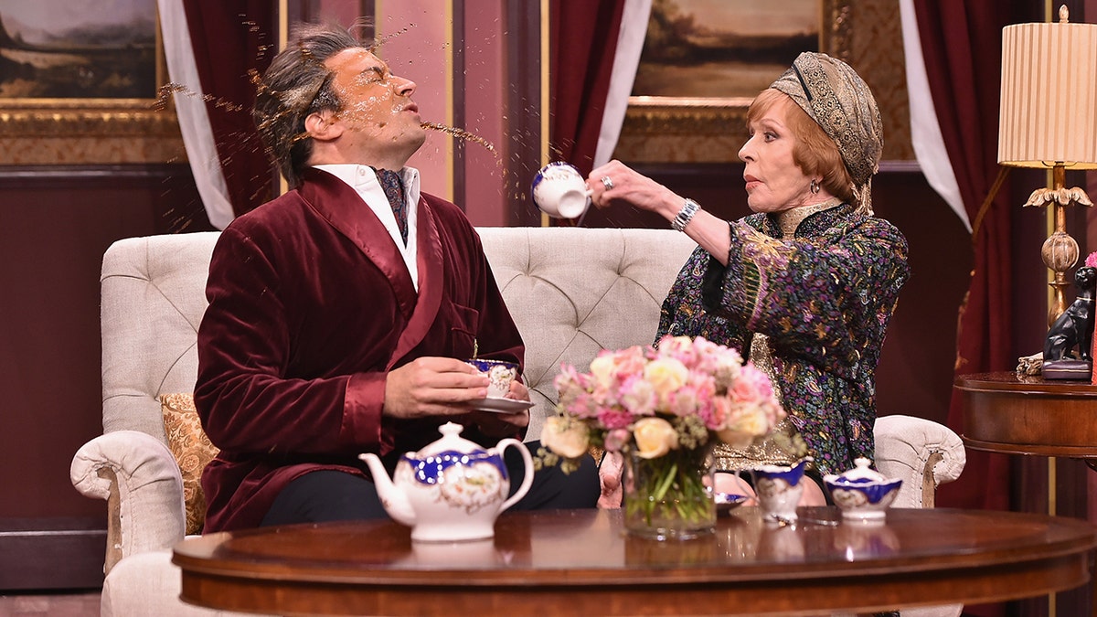 Carol Burnett throwing a drink at Jimmy Fallon during a sketch