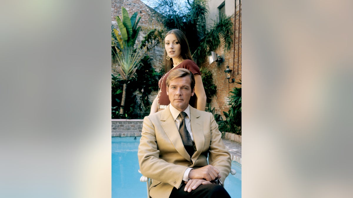Roger Moore and Jane Seymour posing in front a pool