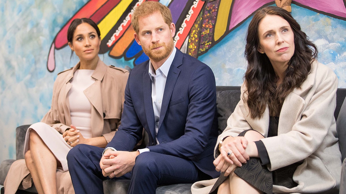 Meghan Markle, Prince Harry and Jacinda Ardern looking away from the camera and sitting together