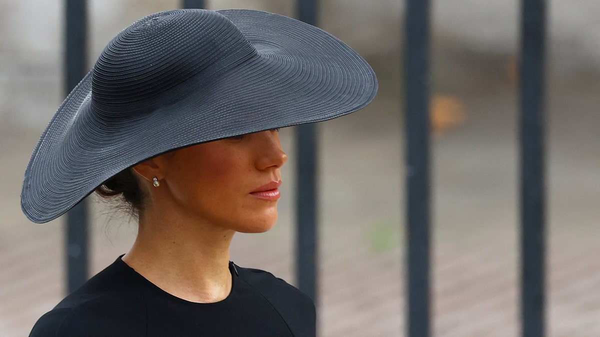 Meghan Markle wearing a black hat with a matching black dress during Queen Elizabeths funeral