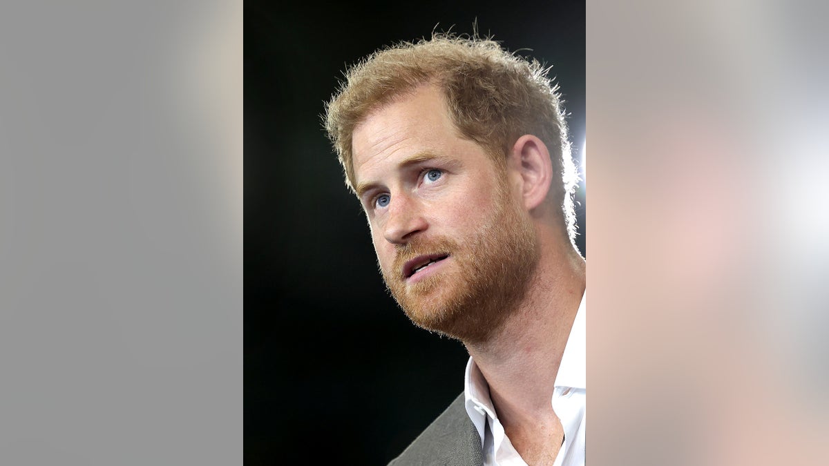 A close-up of Prince Harry wearing a white shirt and a grey blazer