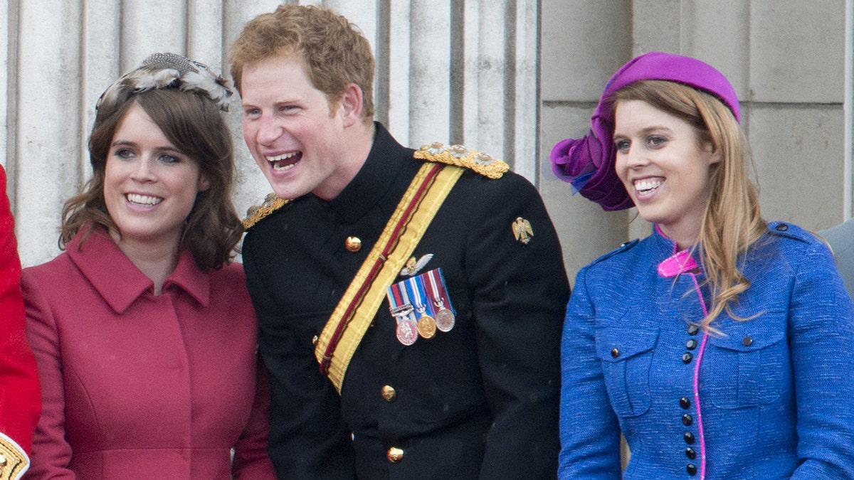 Princess Beatrice, Prince Harry And Princess Eugenie smiling in formal wear will standing on the balcony of Buckingham Palace