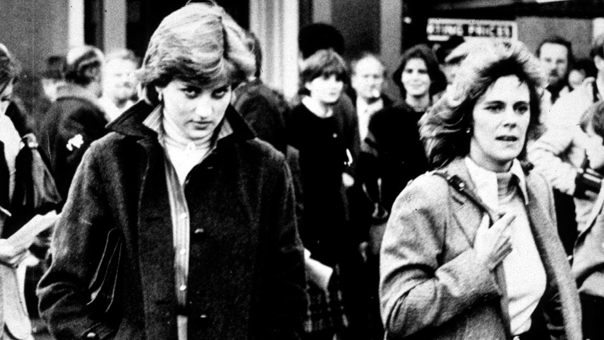 A black and white photo of Princess Diana walking alongside Camilla