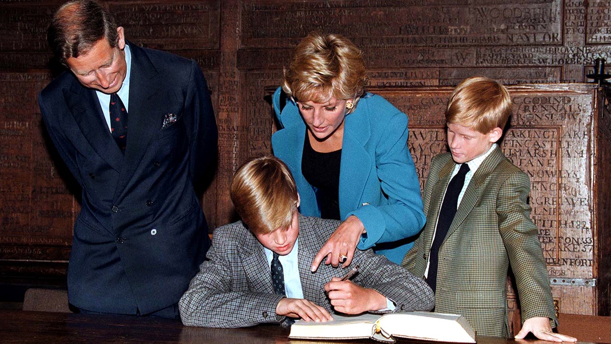 Princess Diana pointing at Prince Williams book while Prince Harry and Prince Charles watch on