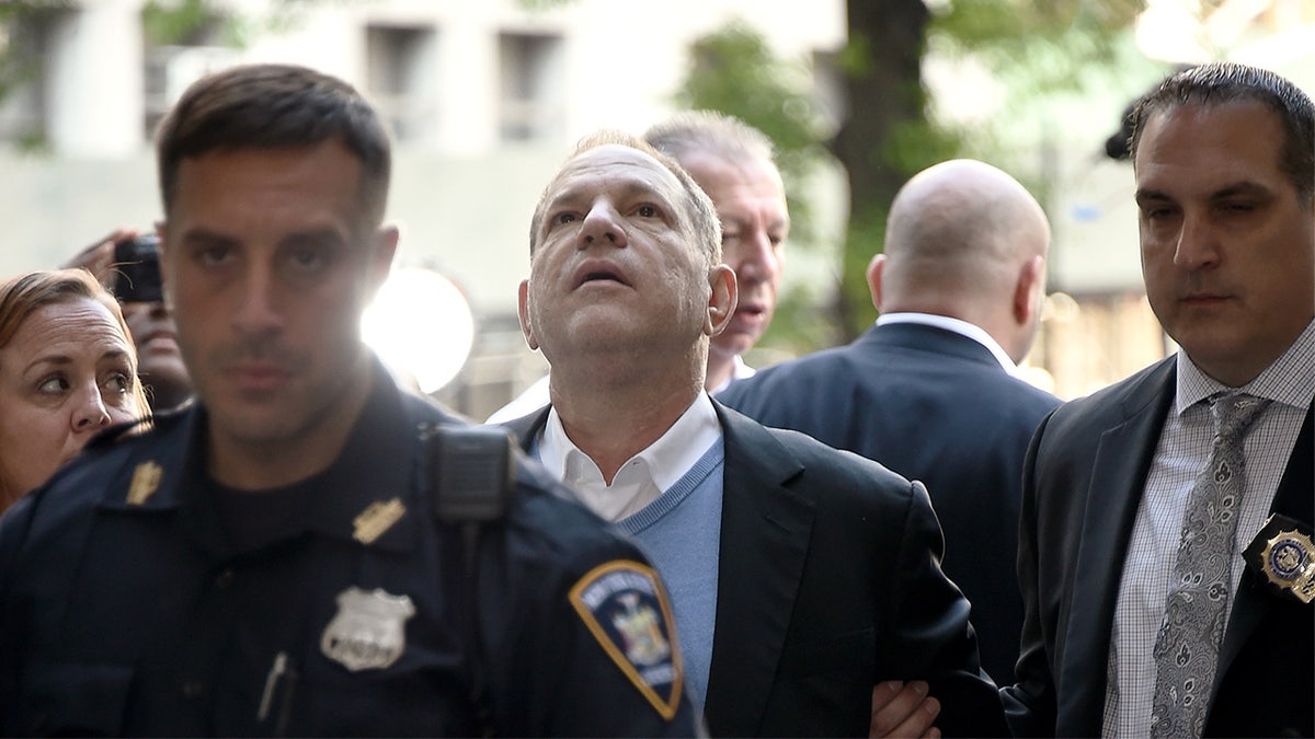 Harvey Weinstein looks up at the sky after his arrest on rape charges.