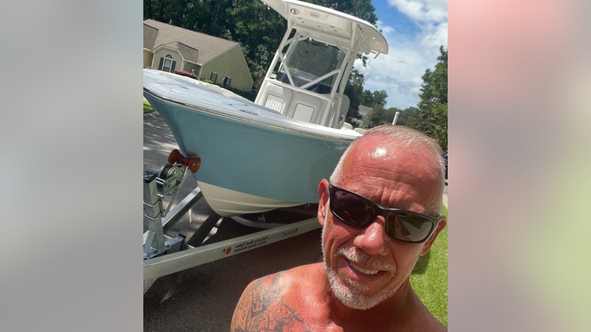 David Hollars poses near a boat