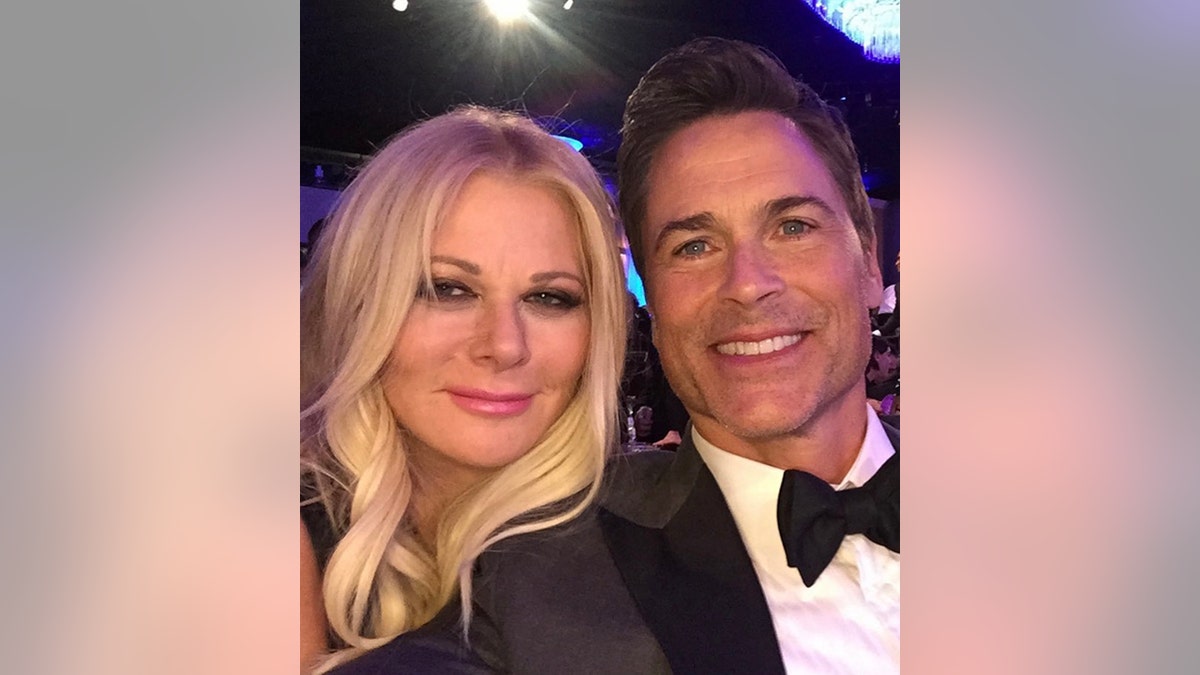 Rob Lowe in a tuxedo takes a selfie with his wife Sheryl inside a theater