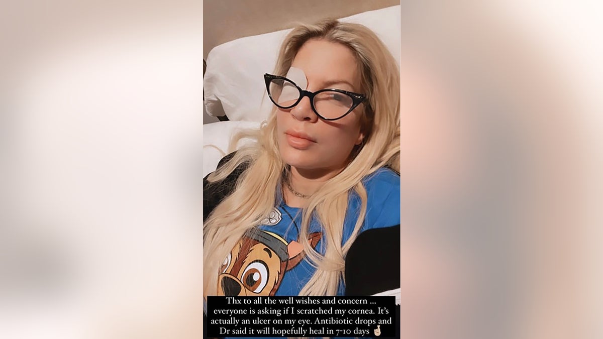 tori spelling laying in bed with eye patch