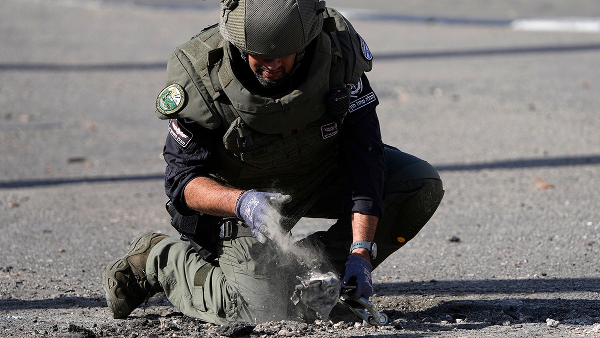 Israeli police officer removes remains of rocket shot from Lebanon