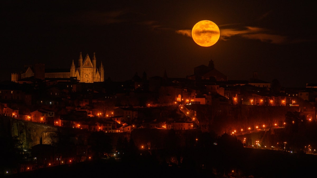 A full moon rises next to the Orvieto Cathedral in Umbria, Italy