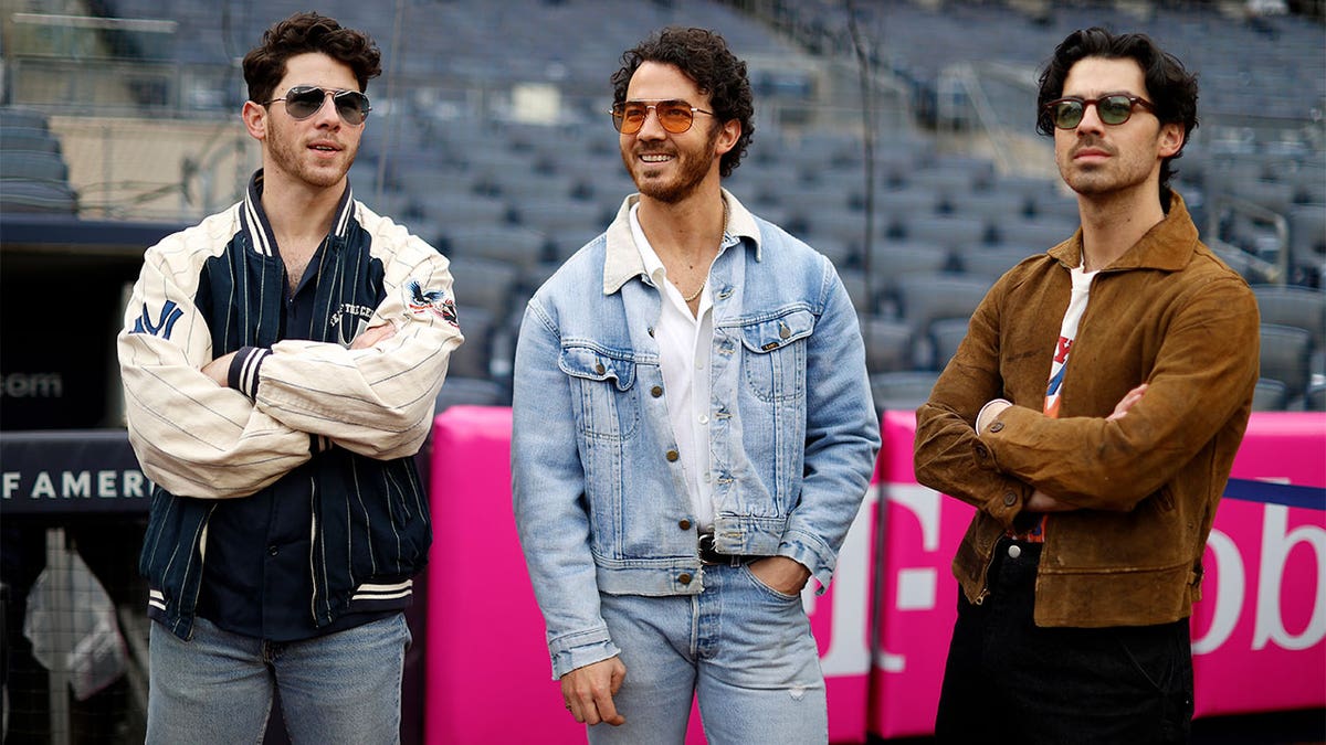 The Jonas Brothers standing in a stadium.