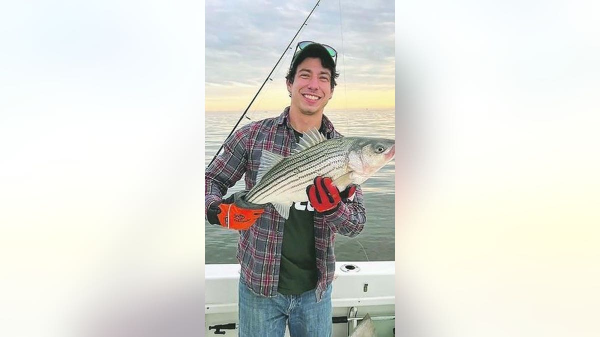 Jonathan Honey holds a freshly caught fish