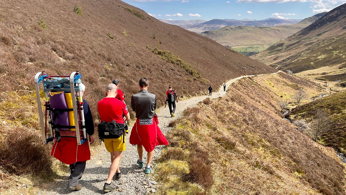 rescuers walking down mountain trail