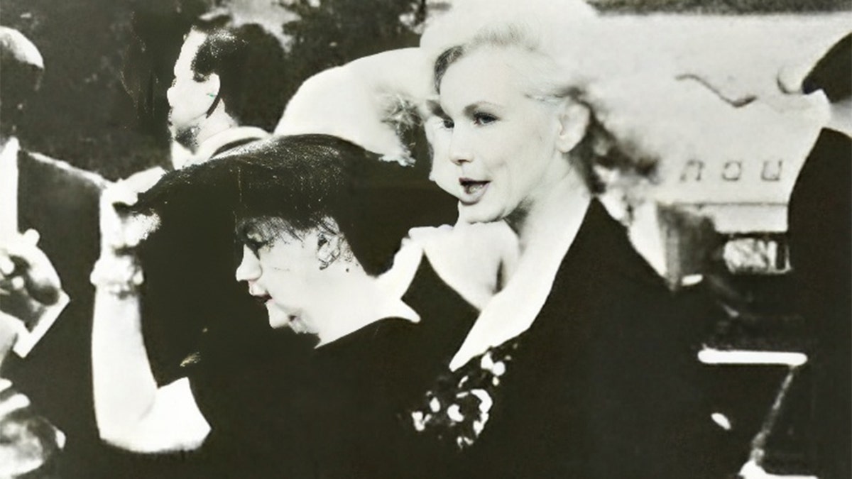 Marilyn Monroe and Judy Garland walking side by side in black outfits