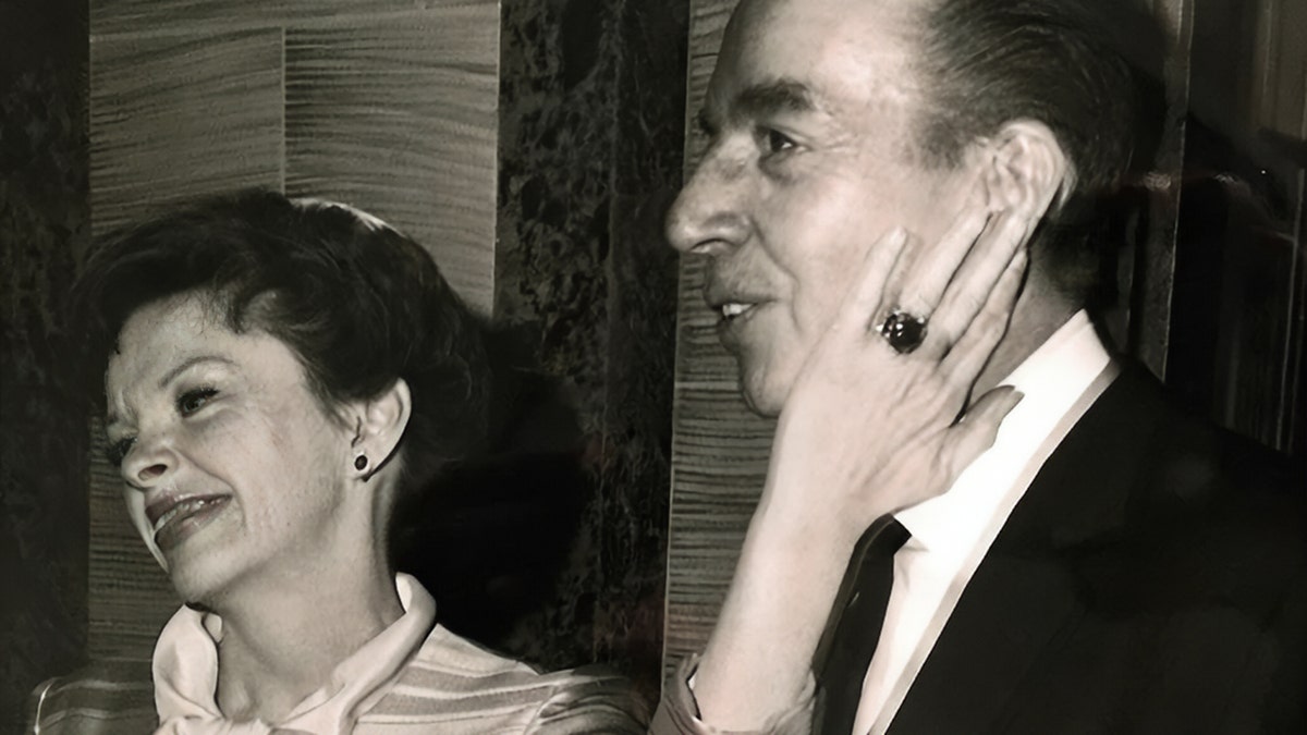 Judy Garland touching her ex-husbands face while smiling
