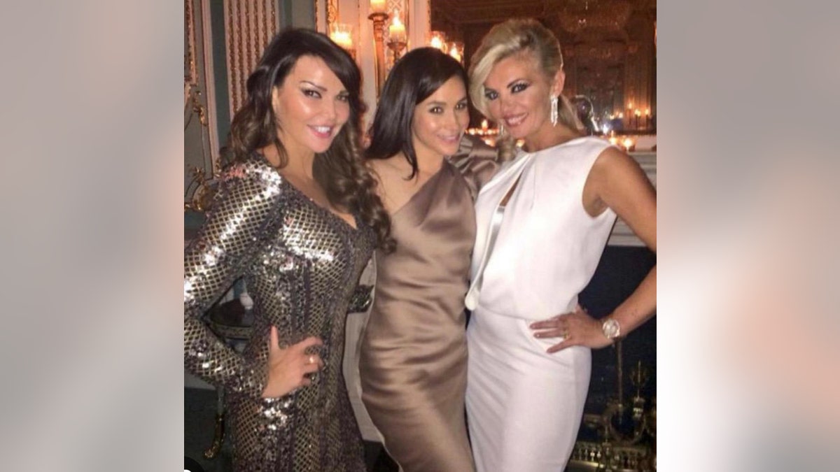 Lizzie Cundy wearing a gold dress, Meghan Markle wearing a bronze dress, and unidentified friend wearing a white dress