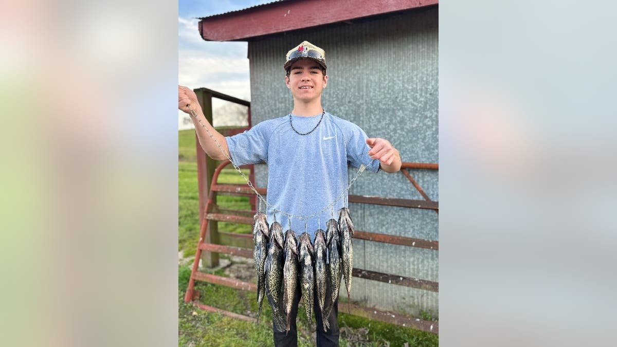 Logan Cernosek holds up a fishing line with seven crappie attached.