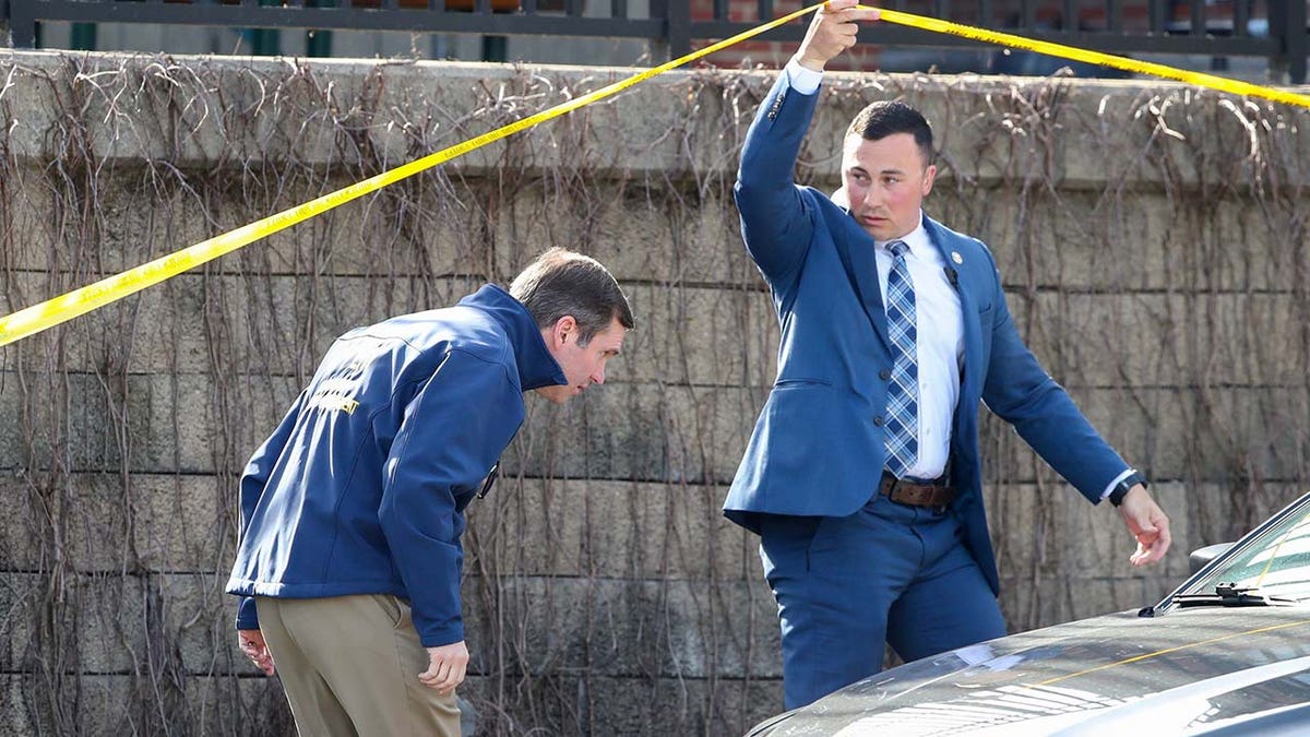 Kentucky Gov. Andy Beshear, left, arrives at the scene of a shooting in downtown Louisville