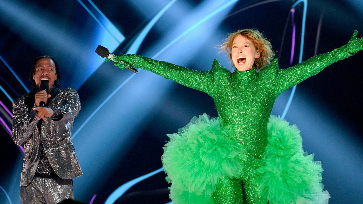 alicia witt arms outstretched unmasked on masked singer