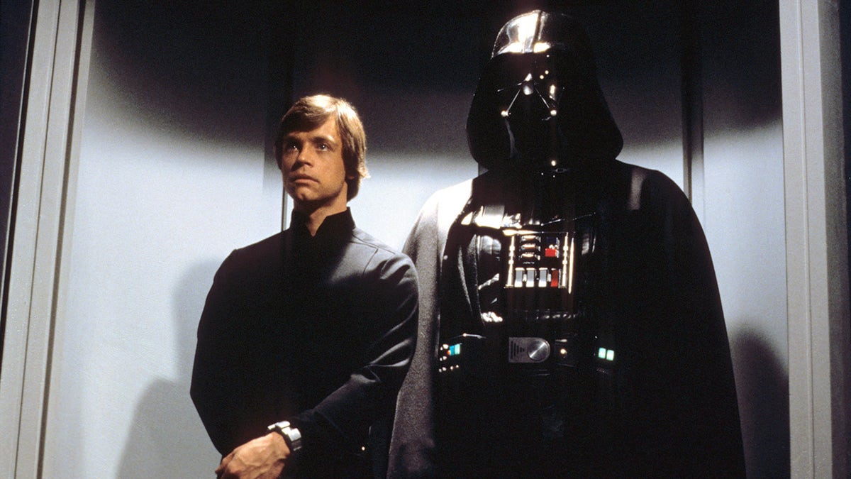 A still from "Star Wars: Episode VI - Return of the Jedi" with Luke Skywalker (Mark Hamill) standing behind Darth Vader
