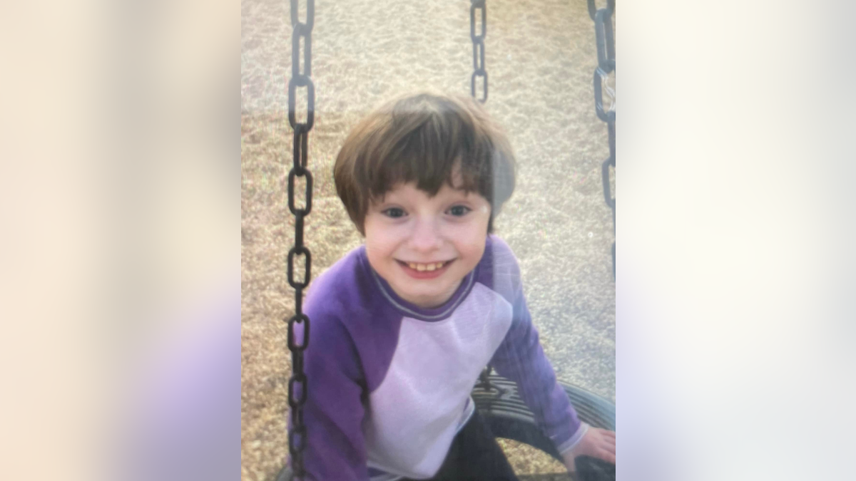 Maddelynn Wallace smiling on swing set