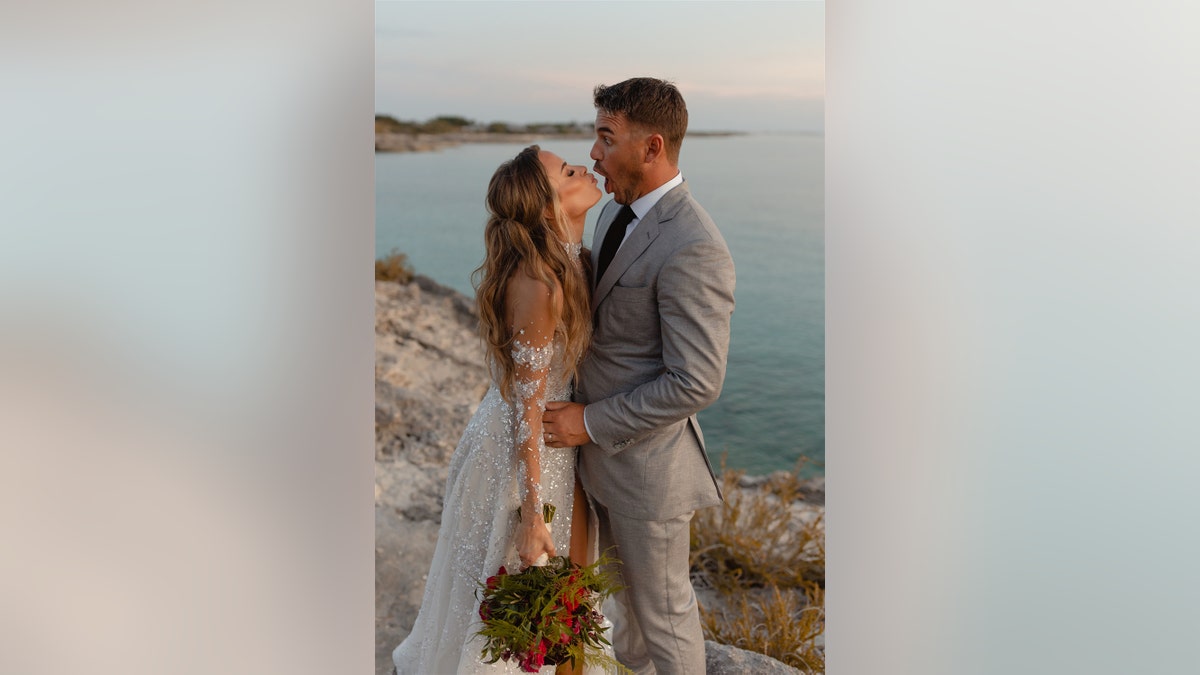 Jena Sims leaning in for a kiss in her wedding dress while Brooks Koepka makes a funny face in a gray suit