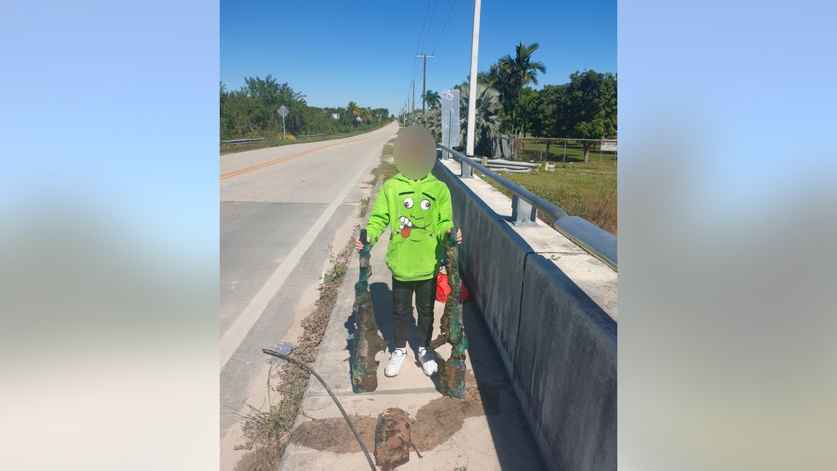 Boy holds two rifles found magnet fishing in Florida