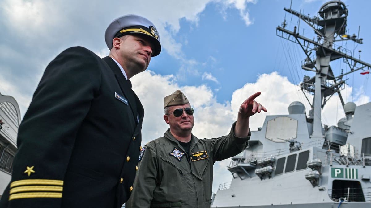 Navy officer on board USS Gravely talking to crew member