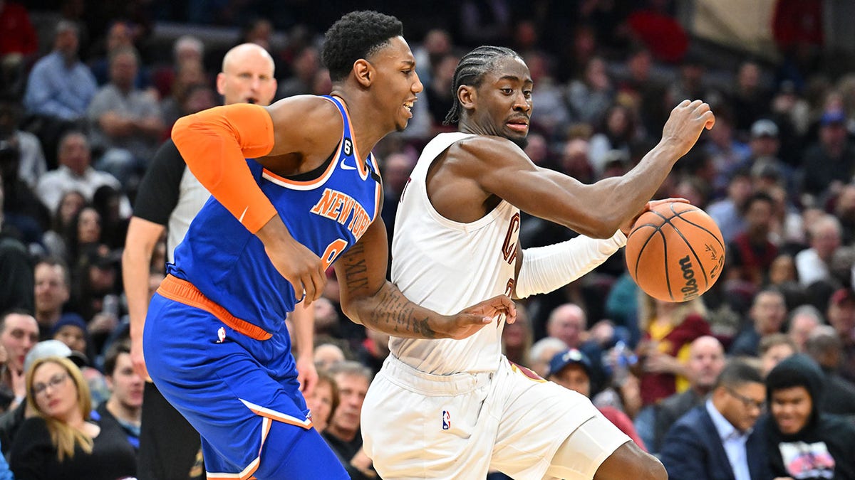 Cavaliers player goes to the basket around Knicks player RJ Barrett