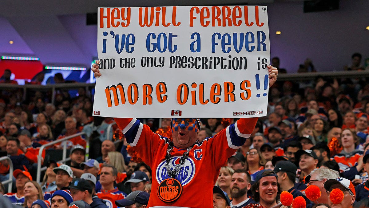 Oilers fan holds a up a sign