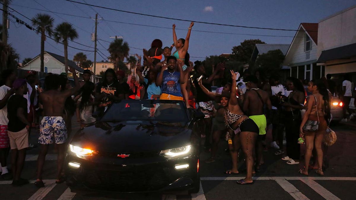 People dancing in the street and on cars as the sun goes down on Tybee Islands Orange Crush