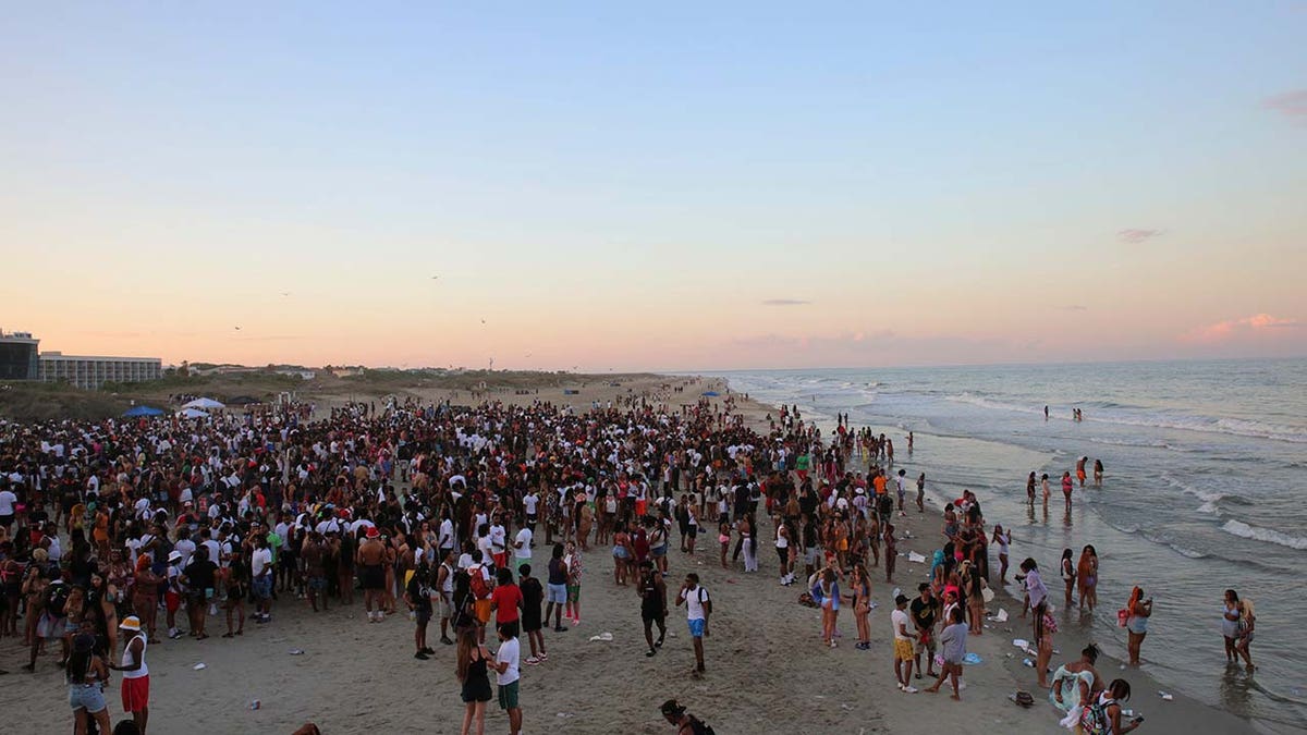 A large crowd of people enjoy the Tybee beach at sunset