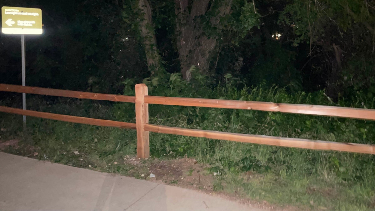 Wooden fencing along the edge of a paved trail